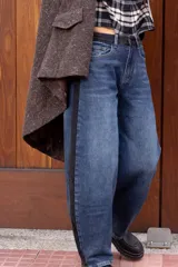 Pantalón de jean estilo mom fit, de tiro alto y corte amplio, con una franja lateral oscura en contraste.