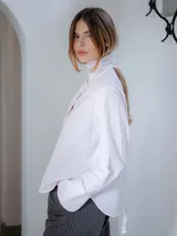 Camisa de corte recto y tejido semitransparente, con cuello mao y cierre frontal oculto por tapeta. Presenta mangas largas con puños anchos y un diseño minimalista.