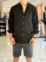 Camisa de lino color beige, de manga larga con puños arremangados y cuello mao. Cuenta con cierre frontal de botones y diseño clásico.