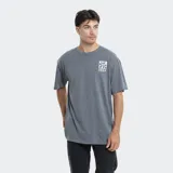 Remera de corte oversize color azul grisáceo, con cuello redondo y estampa pequeña en el pecho con el logo de la marca.