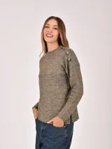 Buzo de tejido de punto color verde oliva, con cuello redondo y botones decorativos en los hombros. Presenta un tejido jaspeado con puntos claros.