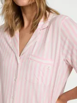 Pijama corto de modal suave con diseño de rayas verticales rosadas y blancas, compuesto por una camisa de manga corta abotonada con bolsillo en el pecho y un short a juego con cintura elástica.