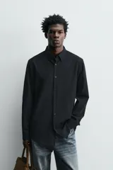 Camisa de corte relajado confeccionada en tejido ligero de lana y algodón. Presenta cuello con botones, manga larga con puños abotonados y cierre frontal de botones.