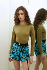 Short de tafeta negro de tiro alto, con botón de nácar y cinturón verde incorporado con tiras largas para atar.