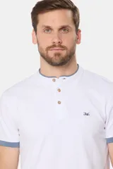 Remera blanca de manga corta con cuello mao y cierre frontal parcial con botones. Presenta detalles en color gris azulado en el cuello y en los bordes de las mangas.