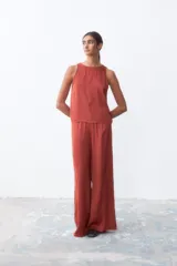 Pantalón palazzo color ladrillo, de tiro alto y corte holgado.