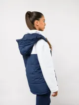 Parka de abrigo Umbro del Club Nacional de Football, con diseño bicolor que combina tejido polar blanco en la parte superior y tejido acolchado azul marino en la parte inferior. Cuenta con cierre frontal completo, cuello alto y bolsillos laterales.