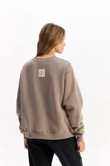 Buzo de algodón color crema, con cuello redondo, mangas largas y calce relajado. Presenta el logo de la marca bordado en el centro del pecho.