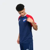 Remera de algodón azul con mangas raglán rojas y detalles en blanco en cuello y puños. Incluye logo de Umbro bordado en el pecho y escudo del Club Nacional de Football.