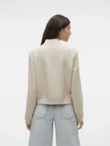 Campera bomber corta de color beige, confeccionada en tejido sarga, con cuello tipo rib, cierre frontal de botones a presión, bolsillos frontales con solapa y puños y dobladillo elasticados.