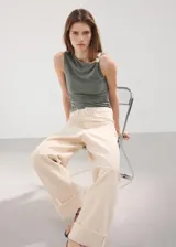 Top verde militar asimétrico de tejido elástico, con tirante ancho decorado con apliques argolla y detalles fruncidos en el lateral.