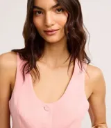 Chaleco cropped sastre color rosado, confeccionado en viscosa, con escote en V, botones delanteros y pences.