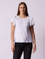 Remera blanca texturizada con cuello redondo y aplique de crochet. Mangas cortas amplias.