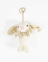 Llavero con dije de conejo de peluche color crema con moño y orejas a cuadros en tonos beige y dorado.