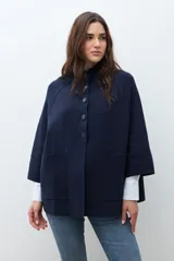 Chaqueta corta de tejido de punto color azul marino, con cuello mao abotonado y mangas tres cuartos. Presenta bolsillos frontales amplios.