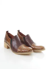 Zapatos de cuero negro con textura de cocodrilo en la puntera y el talón, de corte bajo, con elásticos laterales y taco cuadrado.