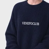 Sweater de punto acanalado en color azul marino, con cuello redondo y diseño holgado. Presenta el logo de la marca bordado en el centro del pecho.