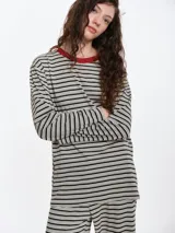 Remera de dormir de corte oversize con estampado de rayas horizontales, confeccionada en algodón con elastano. Presenta cuello redondo en rib de color rojo contrastante y mangas largas.
