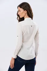Camisa de lino lisa color celeste, de manga larga con puños abotonados y trabilla para arremangar. Cuenta con cuello clásico, cierre frontal con botones y bolsillos plaqué en el pecho.