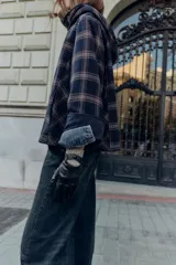 Guantes cortos combinados en efecto piel color negro, con puños de lana en color marrón y detalle de botón a presión.
