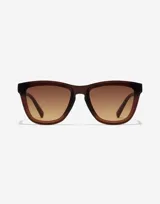 Lentes de sol Hawkers modelo Downtown Max, unisex, con montura cuadrada color marrón y lentes degradadas en tonos marrón y amarillo.