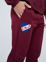 Pantalón de entrenamiento Umbro del Club Nacional de Football, modelo Grok en color azul. Presenta el escudo del club en una pierna y el logo de Umbro en la otra, con diseño cómodo y deportivo.