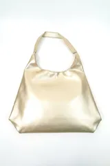 Bolso tipo shopper de color dorado con diseño minimalista, asa integrada y acabado metalizado.