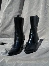 Bota texana negra de caña media con estampado símil piel de cocodrilo y taco cónico.