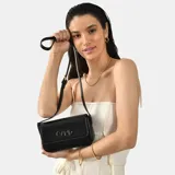 Cartera bandolera negra de cuero sintético con correa ajustable y logo metálico en el frente.