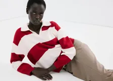 Sweater de punto con diseño de rayas horizontales rojas y blancas, cuello polo y escote en V.