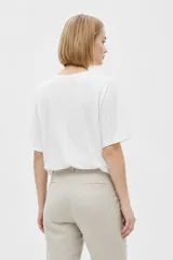 Remera de algodón blanca, de manga corta y cuello redondo con ajuste al cuerpo.