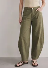 Jean de tiro bajo con fitting baggy y diseño tipo barrel, de color verde militar, con bolsillos delanteros y traseros y cierre de botón y cremallera.