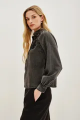 Camisa de liocel color gris oscuro con bordado de flores negras en las mangas largas abullonadas.