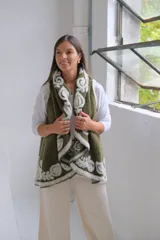 Chaleco abierto de tejido de punto color verde oliva, con bordes decorados con un diseño floral en relieve de color blanco. Presenta una caída fluida y un estilo envolvente.