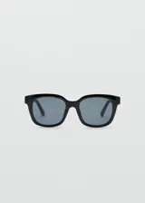 Lentes de sol con armazón de policarbonato negro y diseño cuadrado, con cristales oscuros.