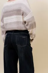 Jean wide leg de tiro alto con calce relajado y pierna amplia. Confeccionado en denim con leve desgaste, cuenta con cintura definida con presillas, bolsillos clásicos y cierre frontal con botón metálico.
