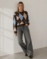 Sweater de tejido bremer con diseño de rombos en tonos marrón, beige y celeste. Presenta cuello redondo, mangas largas y puños acanalados.