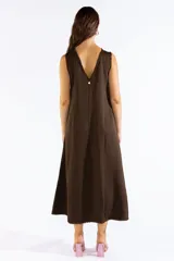 Vestido largo sin mangas color marrón, de corte amplio y fluido con escote bote. Cuenta con bolsillos laterales y detalles de terminaciones deshilachadas.
