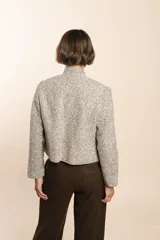 Chaqueta de sastrería color crema, entallada y con cuello erguido. Prenda forrada de lana fina sin teñir.