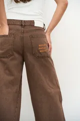 Jeans de corte balloon y pierna ancha, color marrón, con diseño de tiro medio y bolsillos laterales.