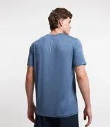 Remera deportiva masculina de manga corta con cuello redondo, confeccionada en tejido técnico con tecnología Dry para mayor transpirabilidad. Presenta detalles reflectantes en los hombros y un diseño liso en color verde melange.