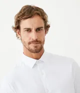 Camisa de manga larga marca Marfinno, confeccionada en tejido dobby de algodón con textura de rayas finas. Presenta cuello inglés y cierre frontal abotonado.