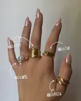 Set de cuatro anillos dorados de diferentes diseños: uno con una perla blanca, uno ancho con forma de cuchara, uno con textura y uno doble.