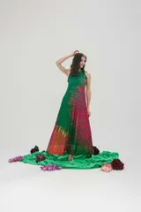 Vestido largo de microtul elastizado y lycra color verde con estampado de plumerillo en tonos rosa, amarillo y naranja. Tiene cuello americano y corte acampanado.