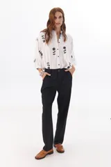 Pantalón de vestir gris oscuro, de corte recto y relajado, con cintura elastizada, cierre de cremallera y botón. Cuenta con bolsillos laterales.
