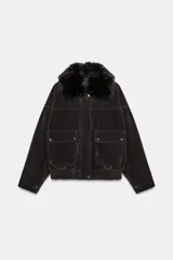 Chaqueta estilo bomber de corte oversize en color marrón oscuro, confeccionada con acabado aterciopelado. Presenta un cuello de solapa con detalle de pelo sintético desmontable, cierre frontal oculto con cremallera y botones a presión, bolsillos delanteros con solapa y bajo elástico.