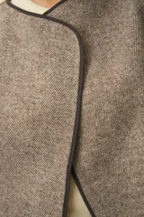 Chaleco color beige con textura tipo espiga, corte holgado y solapa cruzada.