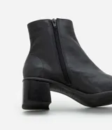 Bota de caña media Satinato confeccionada en cuero color marrón, con diseño de punta cuadrada y tacón bloque mediano.