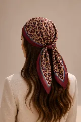 Pañuelo cuadrado de seda con estampado de leopardo en tonos beige, bordó y azul. Presenta un borde ancho en color bordó con un fino detalle de línea azul, ideal para usar como accesorio en el cabello o cuello.