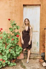 Vestido midi de lycra marrón con escote en V pronunciado tipo halter y falda cruzada asimétrica.